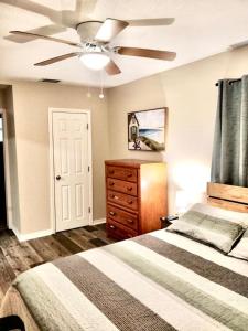 a bedroom with a bed and a ceiling fan at Two Fully Equipped Apartments and a Studio 5 miles from the beach in St. Petersburg