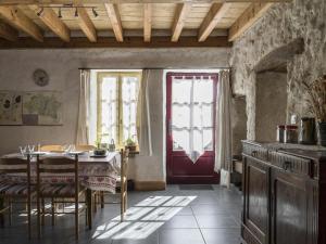 a dining room with a table and a red door at Gîte Saint-Bonnet-de-Rochefort, 3 pièces, 5 personnes - FR-1-489-181 in Saint-Bonnet-de-Rochefort