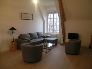 sala de estar con sofá, sillas y TV en Appartement Trévol, 5 pièces, 8 personnes - FR-1-489-215, en Trévol