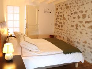 ein Schlafzimmer mit einem weißen Bett und einer Steinmauer in der Unterkunft Gîte Louroux-de-Beaune, 4 pièces, 6 personnes - FR-1-489-349 in Louroux-de-Beaune