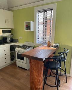 cocina con mesa de madera y 2 sillas en Montete Cottages, en Choiseul