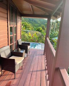 un porche de una casa con sillas y una piscina en Montete Cottages, en Choiseul