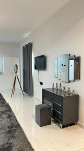 a room with a dresser and a tv and a mirror at Bidiyah arco hotel in Bidiyah
