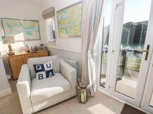 a living room with a chair and a sliding glass door at Yacht Haven View in Milford Haven