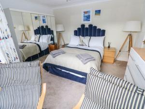 a bedroom with a large bed and two chairs at Yacht Haven View in Milford Haven