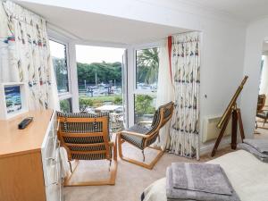 a room with two chairs and a desk and windows at Yacht Haven View in Milford Haven