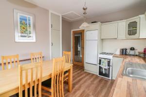 cocina y comedor con mesa de madera y sillas en Rockwood Cottage, en Wexford