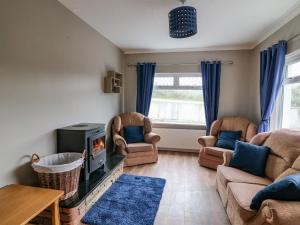 sala de estar con 2 sofás y chimenea en Rockwood Cottage, en Wexford