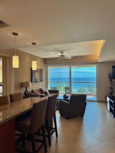 a living room with a dining table and a view of the ocean at Beachfront Condo DelCanto Resort in Nuevo Vallarta