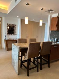 a kitchen with a table with chairs and a counter at Beachfront Condo DelCanto Resort in Nuevo Vallarta