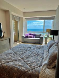 1 dormitorio grande con 1 cama grande y 1 sofá en Beachfront Condo DelCanto Resort, en Nuevo Vallarta 