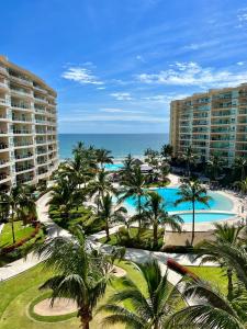 una vista aérea de un complejo con palmeras y el océano en Beachfront Condo DelCanto Resort, en Nuevo Vallarta 