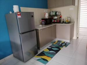 a kitchen with a refrigerator and a kitchen rug at H&H Lovely Homestay in Nilai (Residensi Lili) in Nilai