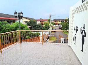 einen Balkon mit einem Zaun und einer Wand mit Gemälden in der Unterkunft Klebang Seacove Villa by Nestcove in Malakka