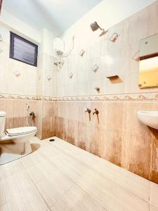 a bathroom with a toilet and a sink at Half Moon Inn in Chennai