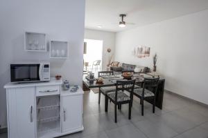 een keuken en een woonkamer met een tafel en een magnetron bij BrotasApart - apto inteiro in Brotas