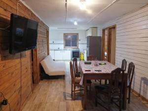 comedor con mesa y TV en una habitación en Agradable Cabaña con Gran Piscina y Tinaja, en Quillón