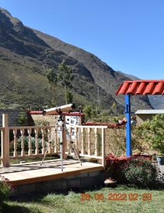 un telescopio en una terraza de madera con una montaña en el fondo en La Finca Tarma, en Tarma