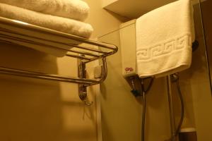 y baño con toallero eléctrico y ducha. en Spaces Hotel Makati en Manila