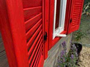 een rode deur met een raam en paarse bloemen bij U Zuzanny - dom z prywatnym jeziorem in Stara Kiszewa