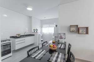 een keuken met een tafel met stoelen en een fruitschaal bij BrotasApart - apto inteiro in Brotas