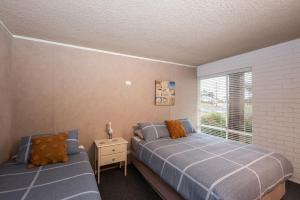 a bedroom with two beds and a window at The Beachy Unit in Portarlington