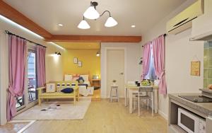 cocina y sala de estar con cortinas rosas y 1 dormitorio en Gyeongju Tiamo Pension, en Gyeongju