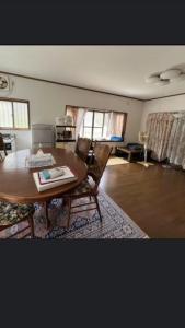 ein Wohnzimmer mit einem Holztisch und Stühlen in der Unterkunft 桃源郷 in Hutami