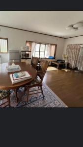 ein Wohnzimmer mit einem Holztisch und Stühlen in der Unterkunft 桃源郷 in Hutami