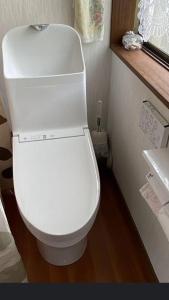 baño con aseo blanco en una habitación en 桃源郷, en Hutami