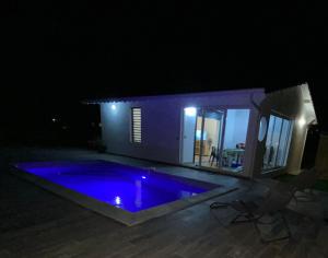 a swimming pool at night in front of a house at Villa Catalina in Le Moule