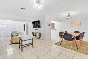- un salon avec une table à manger et des chaises dans l'établissement Private Lakefront Home in Miami/Pembroke, à Pembroke Pines
