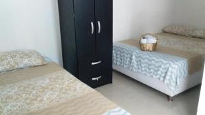 a bedroom with two beds and a black cabinet at CASA FLOR DE LIZ in Villavieja