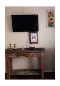 a wooden table with a television on a wall at Aluguel Temporada em Gramado in Gramado