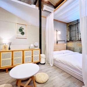 a bedroom with a bed and a table at Jerry's Mazehut Hostel in Tainan