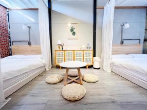 a room with two beds and a table at Jerry's Mazehut Hostel in Tainan