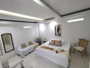 um quarto branco com uma cama e um sofá em Casa Ego em Cartagena de Indias