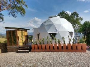 a dome house with a fence and plants at Villa Maria Casa Campestre in San Gil