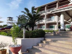 un edificio con una palmera delante de él en Wang Valley Resort en Pantai Cenang