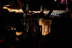 two wine glasses and bottles on a table at night at Villa Maria Casa Campestre in San Gil