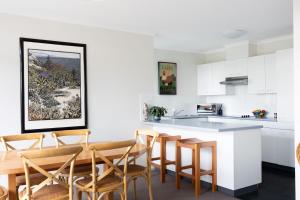 a kitchen and dining room with a table and chairs at Fathoms 17 in Mollymook