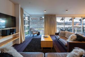 sala de estar con sofá y TV en Absolute Lakefront Location - 3 bedroom apartment, en Queenstown