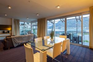 a living room with a glass table and chairs at Absolute Lakefront Location - 3 bedroom apartment in Queenstown