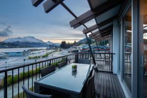 a table on a balcony with a view of a harbor at Absolute Lakefront Location - 3 bedroom apartment in Queenstown