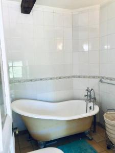 El baño incluye bañera blanca y aseo. en Cottage Trève Raisin, en Perreux