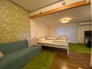 un soggiorno con divano e letto di Bamboo Village Guest House a Naoshima