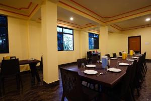 a dining room with tables and chairs and windows at Hotel White Lotus Gangtok in Gangtok