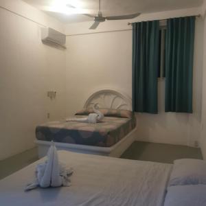 ein Schlafzimmer mit zwei Betten mit ausgestopften Tieren in der Unterkunft Large and comfy apartment, near DT and Principal Beach! in Zihuatanejo