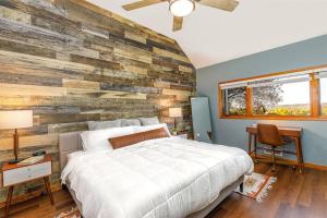 ein Schlafzimmer mit einem großen Bett und einer Holzwand in der Unterkunft Relaxing 2Bedroom Townhome w/Playroom & Great View in Galena