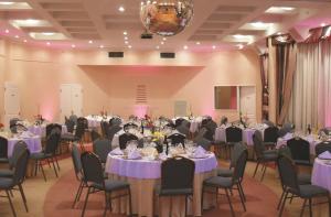 una sala de banquetes con mesas y sillas con mesas de color púrpura en InterTower Hotel en Santa Fe